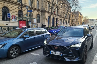 Fotografía de archivo de varios coches que circulan por una calle de París.