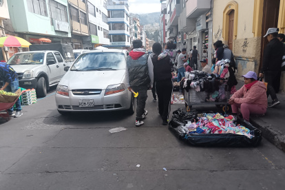 Peatones deben caminar en medio de vehículos, por reubicación de vendedores en la Plaza Primero de Mayo en Ambato.