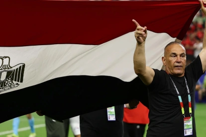 El director técnico de Egipto levanta la bandera nacional durante el partido frente a Argentina.
