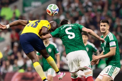 Johan Vásquez (c) de México disputa el balón con Enner Valencia de Ecuador.