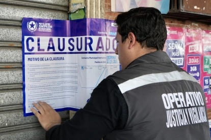 Un funcionario municipal coloca el sello de clausura en uno de los locales intervenidos durante el operativo en el sur de Guayaquil