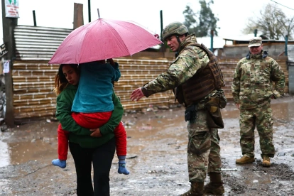 Integrantes del Ejército de Chile evacúan un campamento que presenta riesgo de inundación en la ribera del río Mapocho en Talagante (Chile).