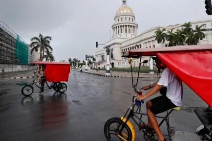 Un par de bicitaxis fue captado este 11 de julio frente al Capitolio de La Habana (Cuba), mientras el país padece el segundo apagón eléctrico nacional de esta semana y el cuarto del año.