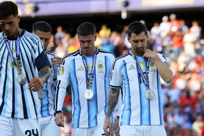 Lionel Messi (d.), Rodrigo De Paul y Enzo Fernández con las medallas de plata.