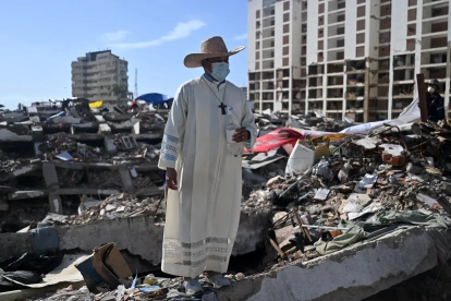 Un sacerdote permanece de pie sobre los escombros de un edificio destruido por los terremotos del 24 de junio en Caraballeda, Venezuela, el 17 de julio de 2026.