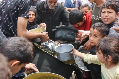 Adultos y niños buscan algo de alimenación.