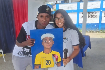 Camila Cotera entrega al mundialista ecuatoriano el retrato que pintó durante tres días.