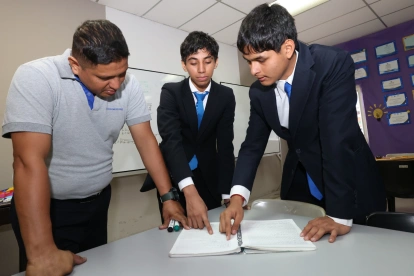 Sebastián Yépez (centro) y Leonel Vargas, del colegio Interamericano, reciben la guía del docente Jhonny Solórzano.