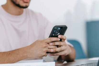 Referencial.Usuario revisa su teléfono tras recibir el aviso de que la cuenta está en revisión en WhatsApp.