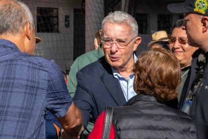 El expresidente (2002-2010), Álvaro Uribe, saluda a un simpatizante a su llegada a un colegio electoral para votar durante la segunda vuelta de las elecciones presidenciales del 21 de junio de 2026.