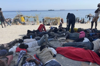 Numerosos inmigrantes permanecen en la playa del Trampolín que se ha transformado en un asentamiento desde la entrada masiva registrada el 30 de julio en la ciudad española de Ceuta.