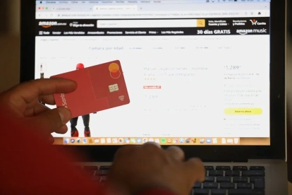 Una persona hace compras en línea usando su tarjeta bancaria.