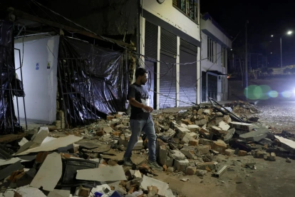 Una persona camina cerca de escombros de viviendas afectadas luego del terremoto.