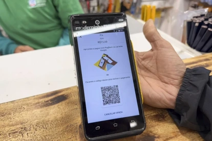 Fotografía de una persona mostrando un código QR del método de pago Pix, en Sao Paulo (Brasil).