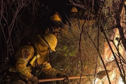 Bomberos trabajan para combatir un incendio forestal cerca de Quito.