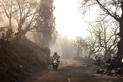 Un hombre pasa cerca de coches quemados tras un incendio forestal cerca de la ciudad de Omis, Croacia, el 14 de agosto de 2026.