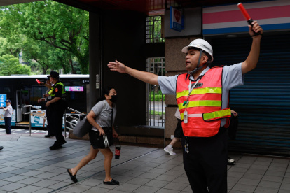 Personal de seguridad guía a las personas para que se refugien dentro de una estación de metro durante el simulacro de ataque aéreo de Wan-An o simulacro urbano, el 13 de agosto de 2026.