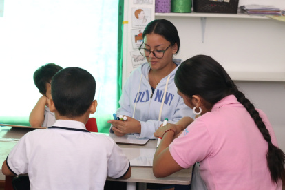 Una maestra junto a jóvenes en un centro de apoyo terapéutico.