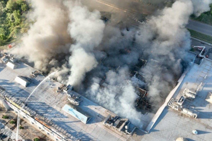 Bomberos participando en las labores de extinción de un incendio en un centro comercial dañado tras un ataque ruso en Kryvyi Rih, en el contexto de la invasión rusa de Ucrania.