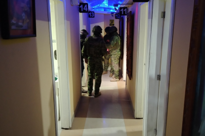 Agentes policiales inspeccionan el interior del night club en Cuenca, donde se halló una caleta con dinero oculto.