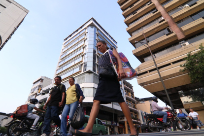 Ciudadanos caminan por la intersección de las calles Lorenzo de Garaycoa y Clemente Ballén, en el centro de Guayaquil, rodeados por edificios.