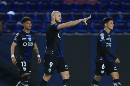 Carlos González (c.), celebra un gol con dos compañeros.