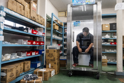 Taichi Konishi, empleado de Konoe, descansa en una cabina de refrigeración para trabajadores, también conocida como "nevera humana", en el almacén de la empresa, en un día caluroso en Higashiosaka, prefectura de Osaka.