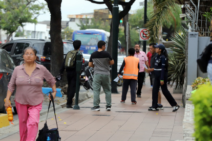 En Urdesa se pueden encontrar personas cuidan carros junto a los parquímetros.