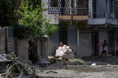 Los supervivientes de las inundaciones regresan a sus hogares tras una crecida repentina en la aldea de Devighat, distrito de Nuwakot, Nepal, el 27 de agosto de 2026.