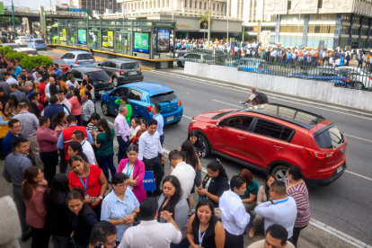 Empleados de oficina permanecen fuera de los edificios tras la evacuación provocada por el fuerte terremoto que sacudió la Ciudad de Guatemala el 8 de julio de 2025.