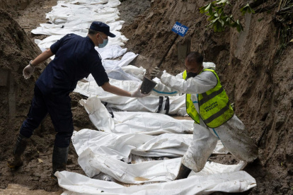 Agentes de la policía nepalí realizan un entierro masivo de víctimas de las inundaciones que golpearon el norte de Nepal.