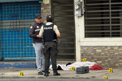 Agentes policiales resguardan la escena del crimen donde fue asesinado un bombero en Machala.