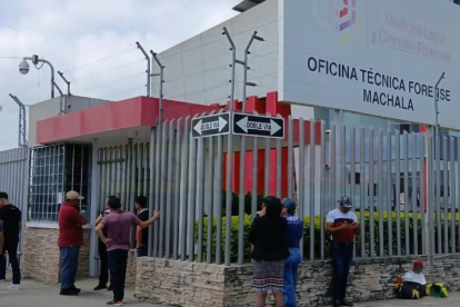 Familiares esperan en los exteriores de la Oficina Técnica Forense de Machala, donde permanecen restos de víctimas que aún no han podido ser identificados.