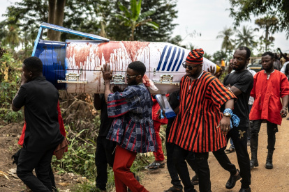 Los familiares llevan el ataúd en forma de bolígrafo manchado de sangre de oveja del difunto maestro ghanés Samuel Commey Tetteh, el 15 de agosto de 2026.