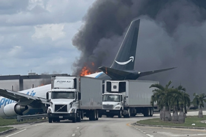 El avión quedó envuelto en llamas y denso humo negro tras colisionar con varios vehículos.
