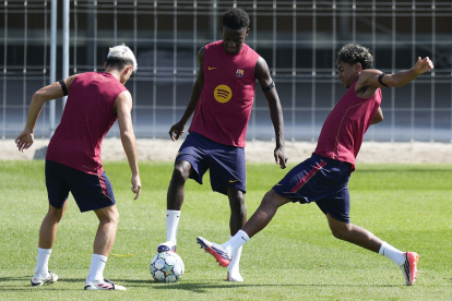 Los jugadores del FC Barcelona Pedro González 'Pedri' (i), Jesse Bisiwu (c) y Lamine Yamal (d) durante el entrenamiento.
