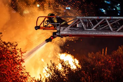Personal bomberil intenta sofocar las llamas en el sector de La Vicentina, cerca de la avenida Velasco Ibarra, en Quito, la noche de este miércoles 16 de septiembre.