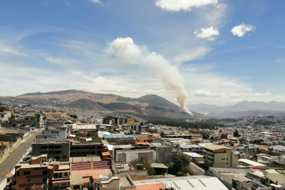 Un helicóptero de Bomberos realiza descargas de agua sobre Casitagua para apoyar las labores terrestres durante el incendio forestal registrado este jueves.