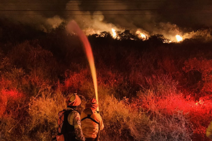 Bomberos de Quito intentan sofocar las llamas en el cerro Casitagua.