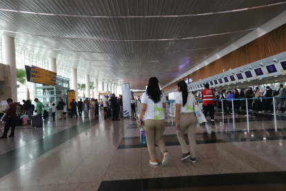 VISTA DE PASAJEROS CAMINANDO POR LOS PASILLOS DE LA TERMINAL AÉREA ||