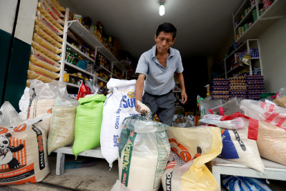 Un comerciante muestra que el arroz de grano largo es de mejor calidad y que la libra cuesta 0,50 dólares.