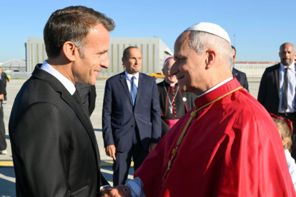 El papa León XIV (d) es recibido por el presidente francés, Emmanuel Macron (i) a su llegada al aeropuerto de París-Orly, Francia.