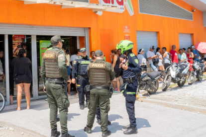 Integrantes de la Policía de Colombia custodian un negocio tras la violencia desatada por las paramilitares ACSN en Santa Marta (Colombia).