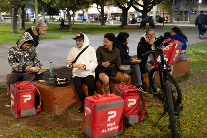 Repartidores cenan en una jornada de asistencia a personas vulnerables en Buenos Aires (Argentina).