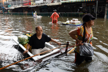 Un hombre tailandés se sienta en una balsa casera entre las aguas de una inundación después de comprar alimentos en Bangkok, Tailandia, el 28 de septiembre de 2026.