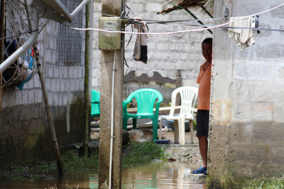 Un morador permanece dentro de su vivienda, rodeado por el agua acumulada tras las fuertes lluvias que afectaron a La Unión, en Quinindé.