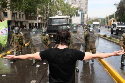 Carabineros de Chile y un manifestante se enfrentan durante la movilización nacional convocada por la Confederación de Estudiantes de Chile.