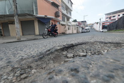 Los baches y el desgaste del asfalto obligan a los conductores a reducir la velocidad y cambiar de trayectoria para continuar por las calles del sector.