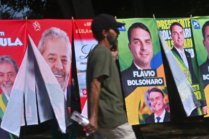 Carteles de los candidatos Luiz Inácio Lula da Silva y Flávio Bolsonaro se venden en calles de la capital Brasilia.