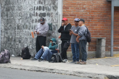 Un grupo de trabajadores con herramientas espera en una vereda. El INEC no publica cifras oficiales de empleo desde mayo y aplazó los datos de junio a octubre hasta el 22 de diciembre.